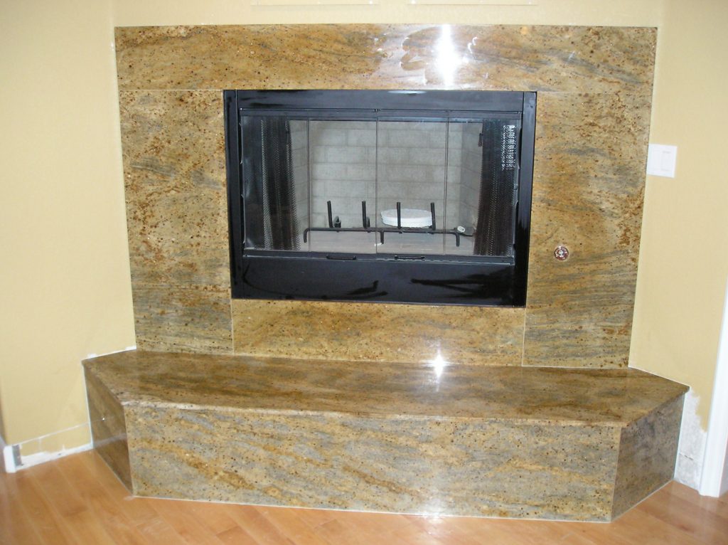 Stone fireplace surround in granite with a raised hearth